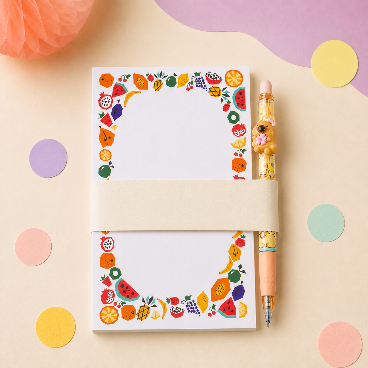 A colorful notepad and playful pen arranged as a coordinated party favor